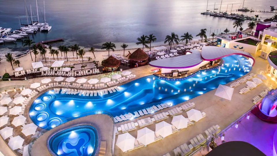 Temptation Cancun Resort pool beside the beach at dusk; operator promotional photograph